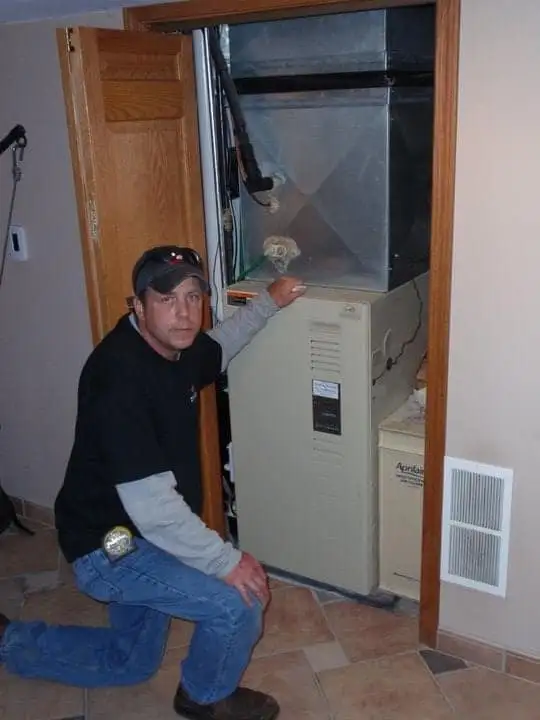 A Hinding technician with a finished furnace installation in a St. Paul home
